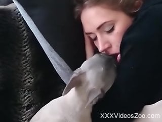 Small dog licks woman's mouth while she's asleep